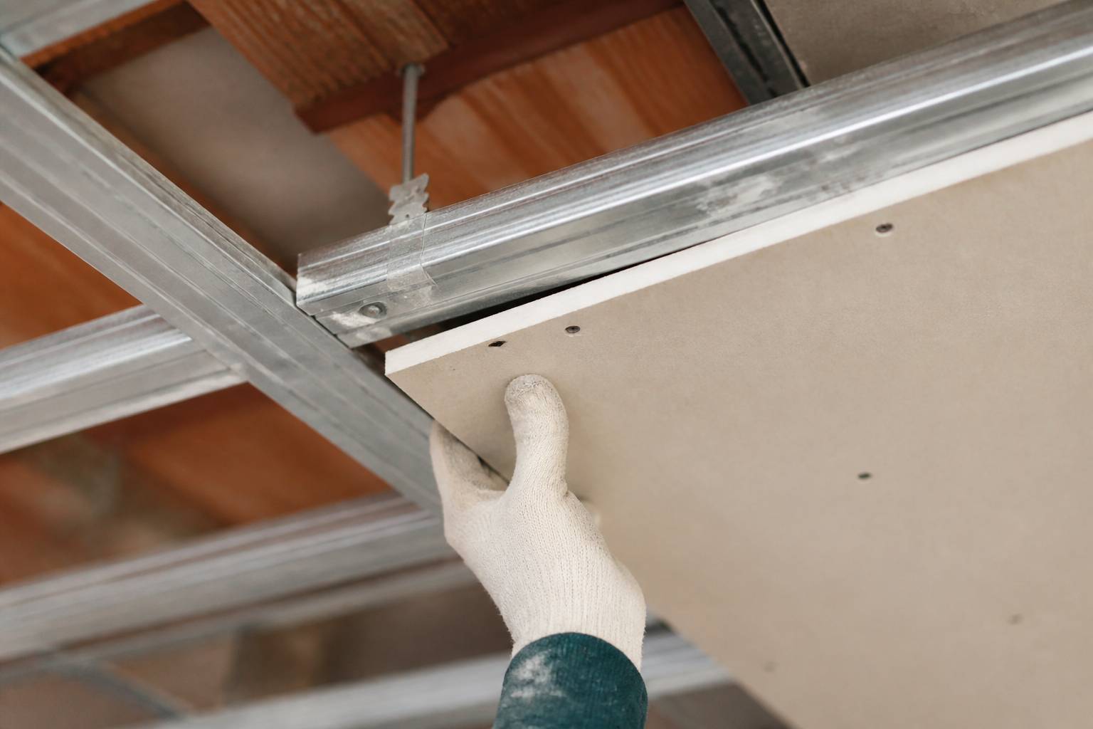 Ossature métallique de plafond suspendu avec plaque de plâtre partiellement vissée